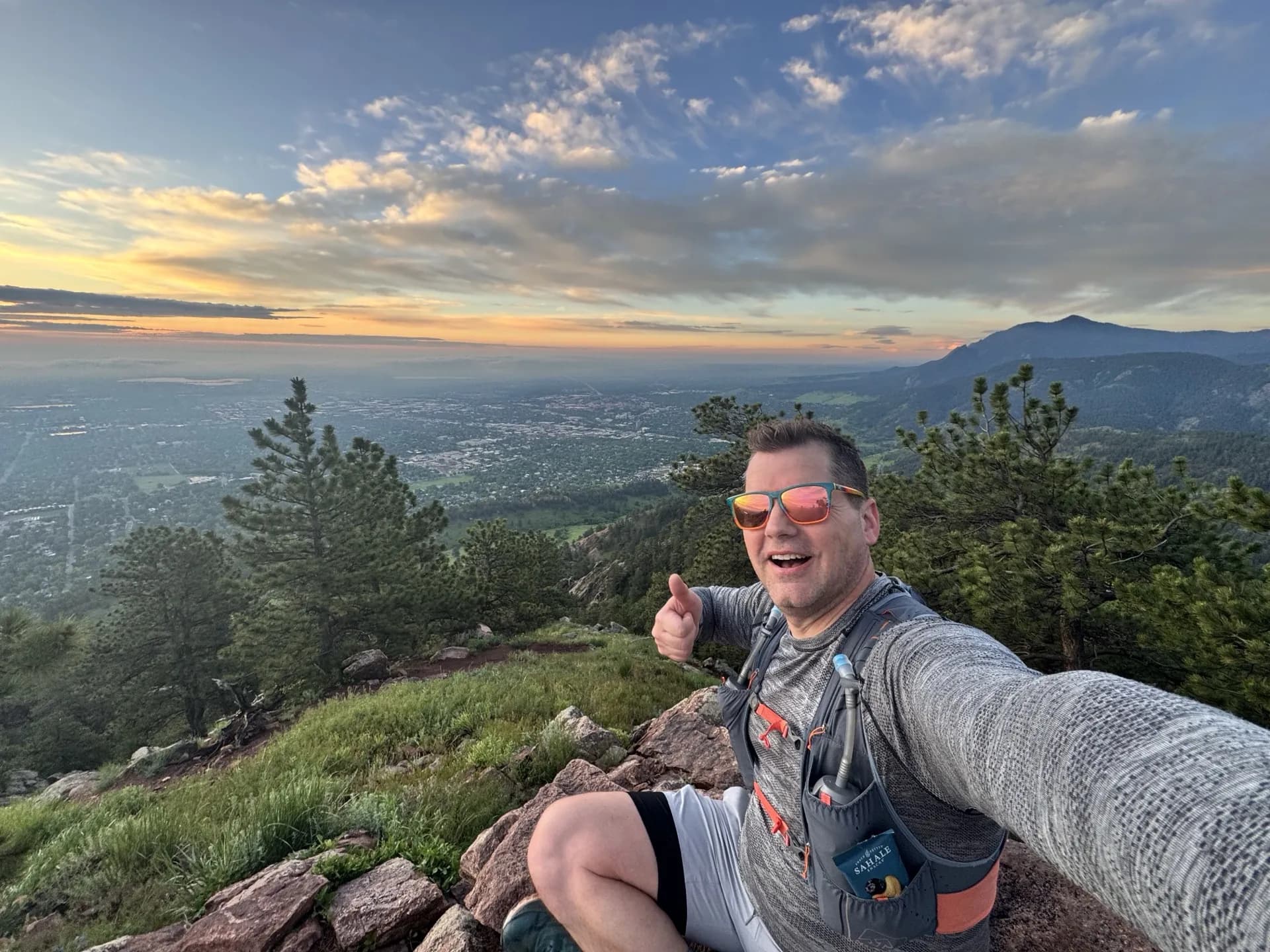 Jason Shearer at a mountain summit at sunset
